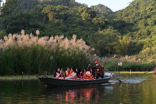 A group of adults wearing life vests on a guided boat tour amid lush greenery and calm waters.